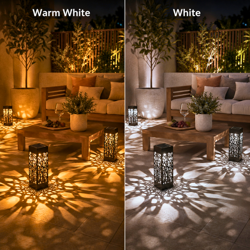 A side-by-side comparison showing outdoor patio lighting in two color modes: 'Warm White' on the left, casting a golden glow, and 'White' on the right, casting a bright white light. Both scenes feature a patio sofa, potted plants, a wooden coffee table, and decorative lanterns casting intricate leaf-shaped shadows on the tiled floor.