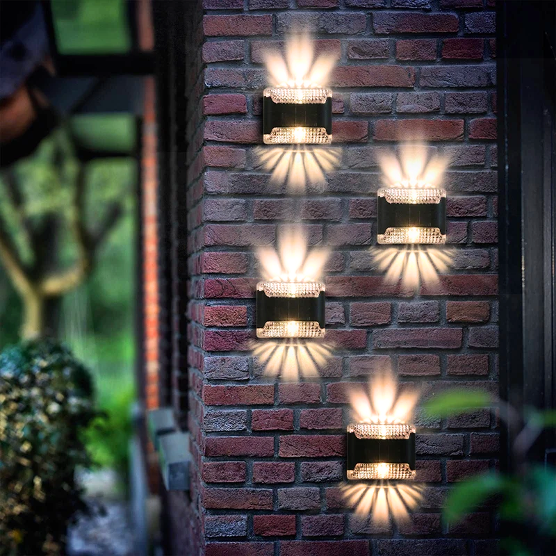 A series of solar-powered wall mount lights installed on a brick wall, emitting a warm white glow.